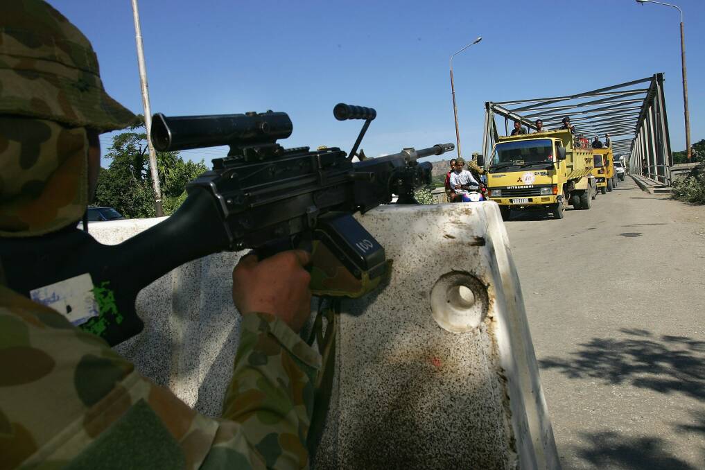 Australian peacekeepers stand guard at a check point monitoring people coming into the capitol city on June 8, 2006 in Dili, East Timor. Photo by Paula Bronstein/Getty Images