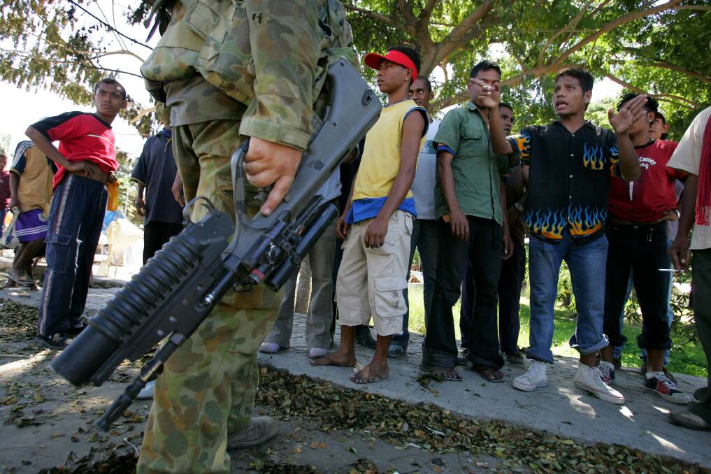 An Australian peacekeeping soldier talks to gang members to try and calm down the streets June 5, 2006 in Dili, East Timor. Photo by Paula Bronstein/Getty Images