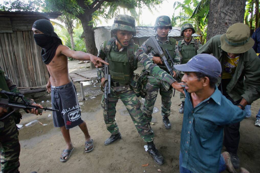 Malaysian peacekeeping troops arrest Julio, a suspected gang member that they believe has torched houses, on June 8, 2006 in Dili, East Timor. Photo by Paula Bronstein/Getty Images