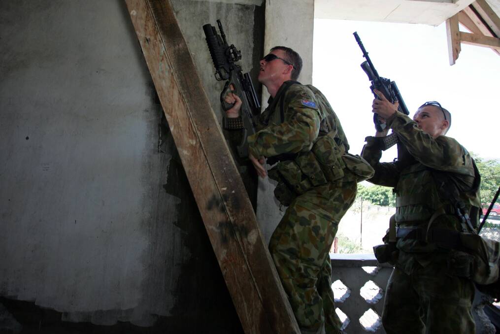 Australian peacekeepers patrol a house after further torchings on June 4, 2006 in Dili, East Timor. Photo by Paula Bronstein/Getty Images