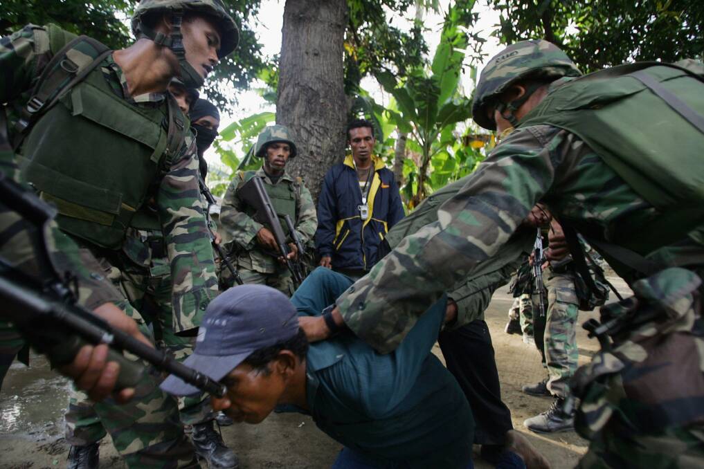 Malaysian peacekeeping troops arrest Julio, a suspected gang member that they believe has torched houses, on June 8, 2006 in Dili, East Timor. Photo by Paula Bronstein/Getty Images