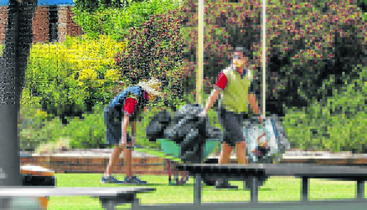 CLEARING UP: Staff wearing protective gear at Borambola Sport and Recreation Centre last week. Photos: Addison Hamilton, The Daily Advertiser