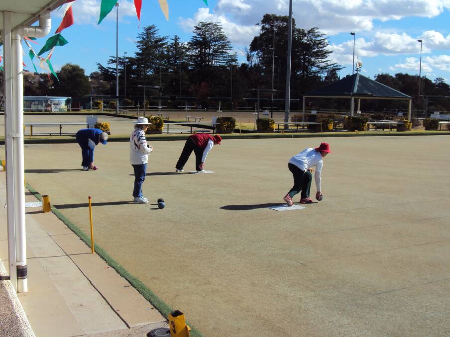 Margo Parker and Ann Gardner play their bowls while Catherine Betcher from Grenfell and Betty Cleveland from Cootamundra wait their turn.
