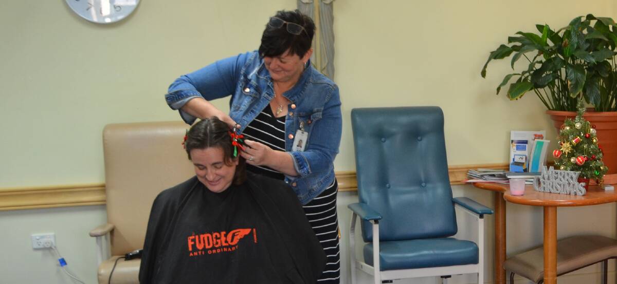 Lucie Flynn gets a shave thanks to the trusty Michelle Pope. The head shaved raised a valuable $500 for the palliative care unit.