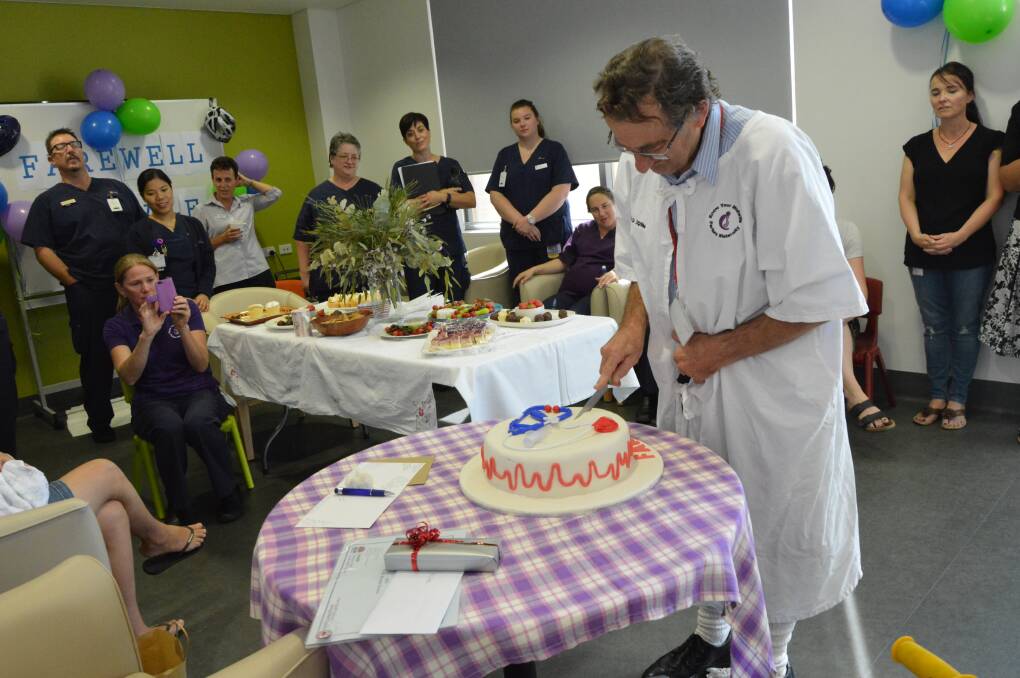 Cutting the cake: Dr John Gale celebrates during his retirement party. Photo: Supplied.
