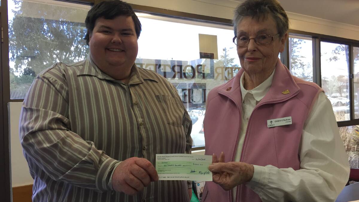 Treasurer James Sheehan on behalf of Burrangong Bears presents Legacy president Mrs O’Sullivan with a cheque for $1000.