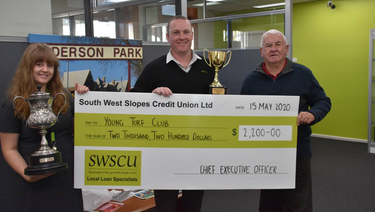 South West Slopes Credit Union operations assistant Tahlia Johnson, CEO Jayson Smith and Young Turf Club's Stuart Maxwell with the Young Cup silverware and sponsor prizemoney from SWS Credit Union. Photo by Peter Guthrie