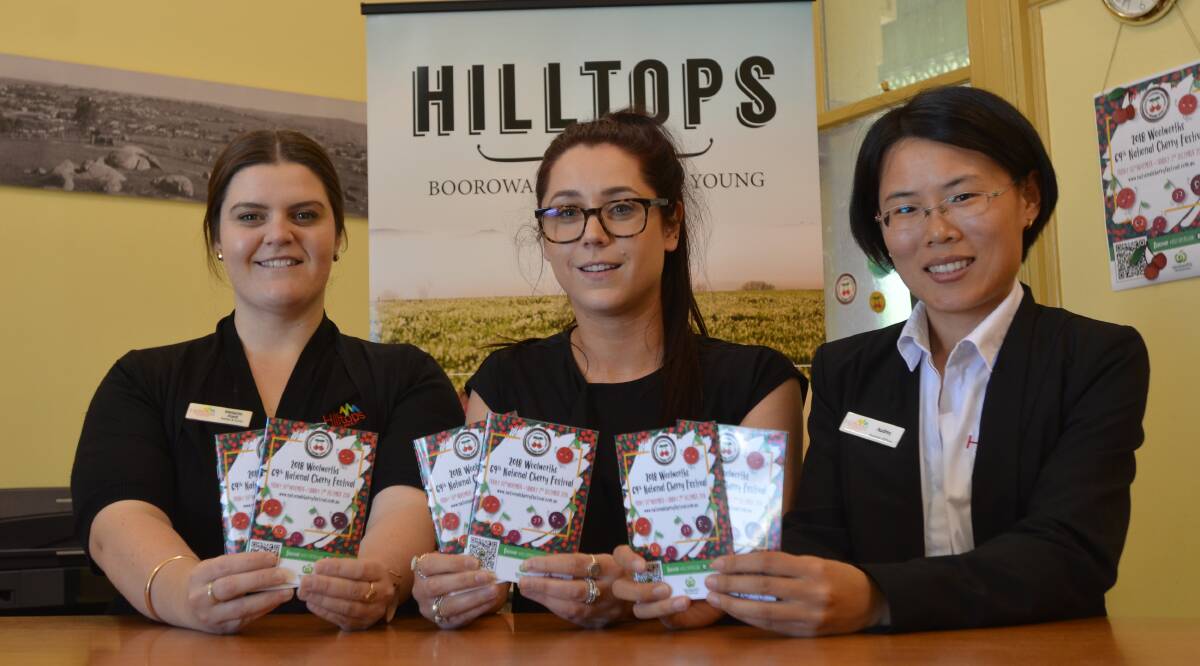 Mel Ford, Emma Hill and Audrey Liu with this year's National Cherry Festival programs at the Young Information Centre.