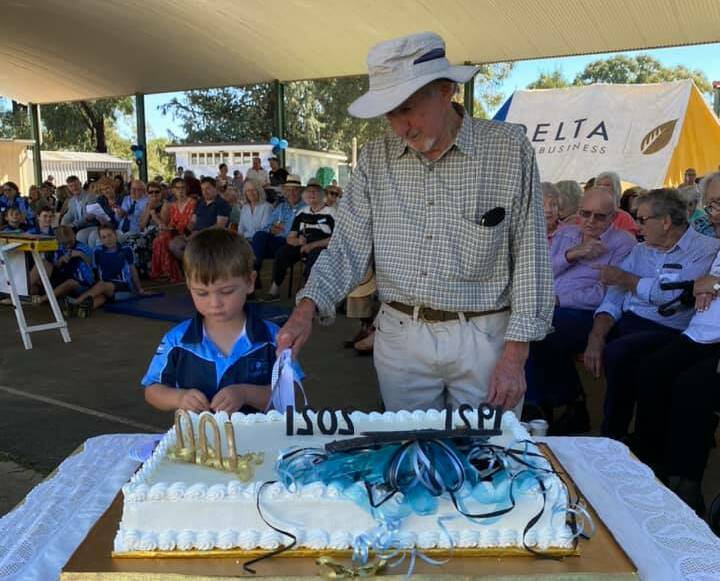 The cake, decorated by Judy Honeman, is cut by the school's youngest student Keith Edgerton and oldest ex-student in attendance Jim Keogh, who started school at Maimuru in 1939. 