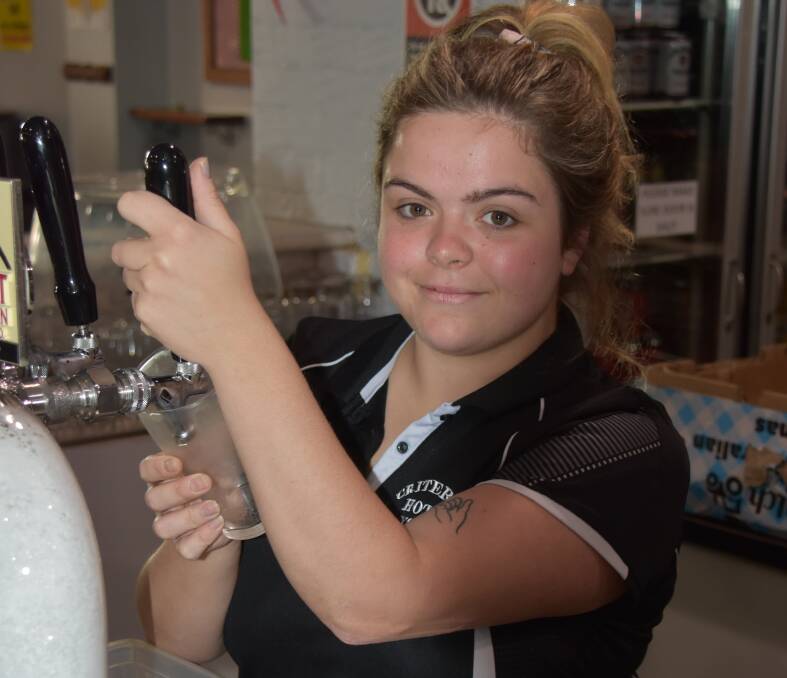 Tammy Waters pulls a beer from the taps at the Criterion Hotel on Monday morning before pubs and clubs closed at midday. Photo: Peter Guthrie