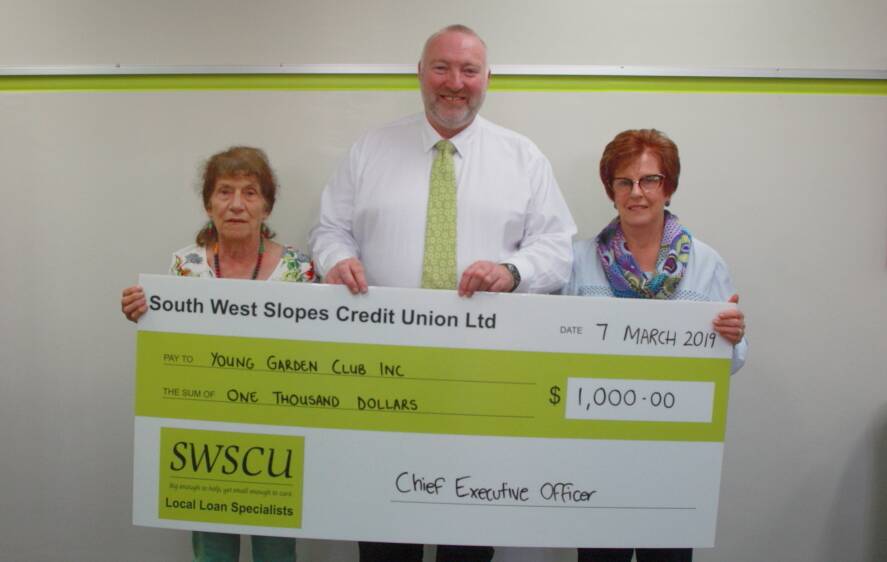 Andrew Jones, CEO of the South West Credit Union, presents Helenie Carmody and Moya van Rijswijk with a $1000 cheque.