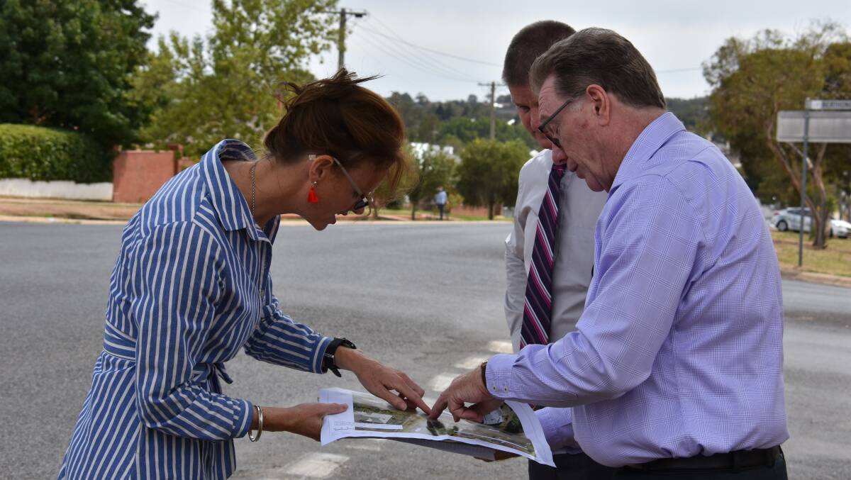 Member for Cootamundra Steph Cooke, Hilltops director of infrastructure John Osland and mayor Brian Ingram inspect designs for the new roundabout to be installed at the intersection of Wombat and Berthong Street. Photo: Peter Guthrie