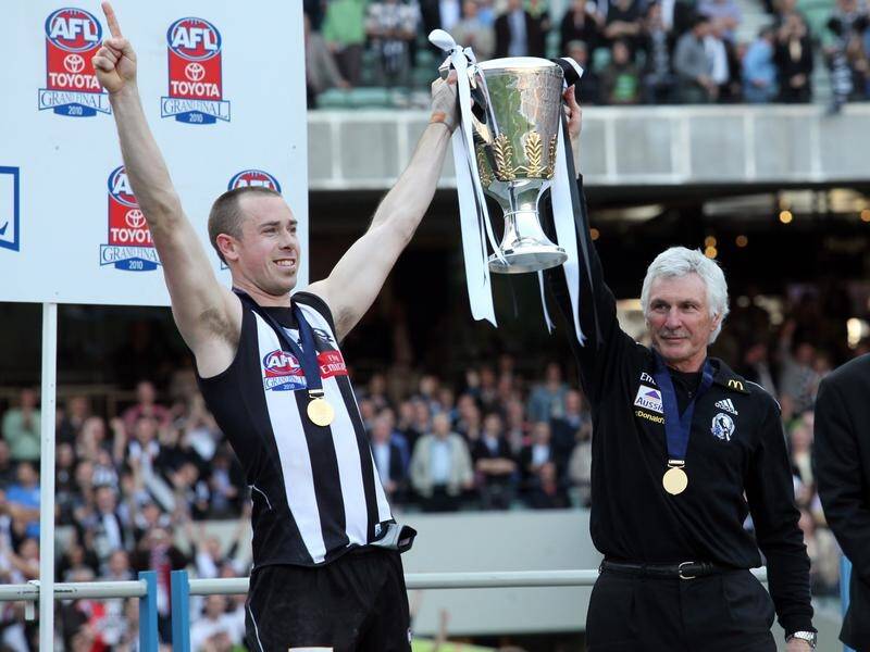 Mick Malthouse (r) won the 2020 AFL premiership trophy in 2010 as coach of Collingwood.