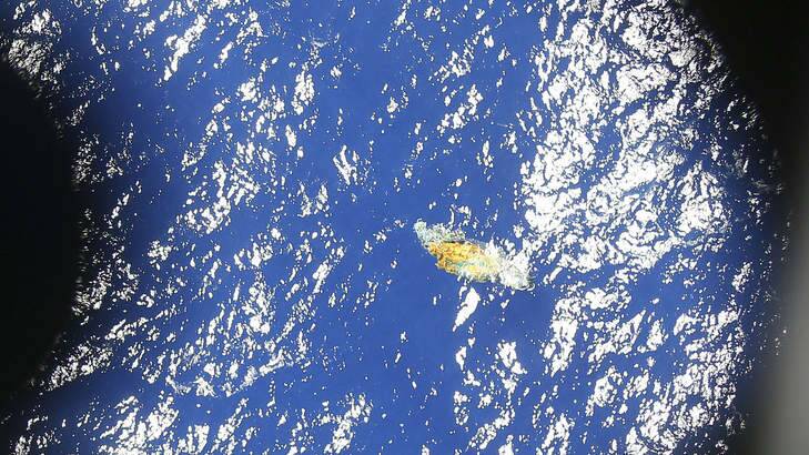 A piece of unknown debris floats just under the water in this image taken by a Royal New Zealand P3 Orion while it searches for missing Malaysia Airlines Flight MH370, over the Indian Ocean. Photo: AFP Photo