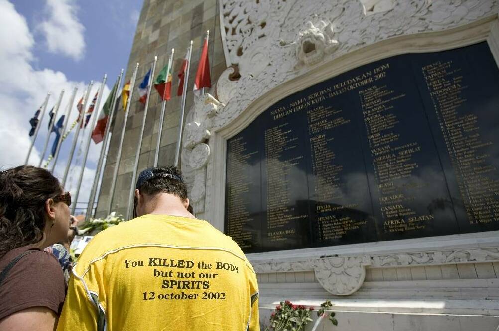 Australian tourists look at the list of thos.e who died at a memorial in Kuta, Bali