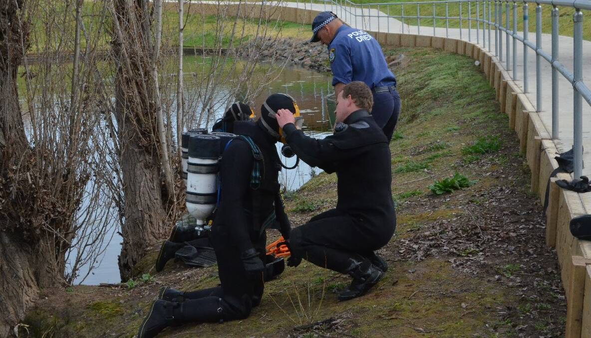 SEARCH: Police divers putting their scuba gear on before performing an under water search. 